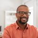 Smiling mature man wearing spectacles looking at camera. Portrait of black confident man at home. Successful entrepreneur feeling satisfied.